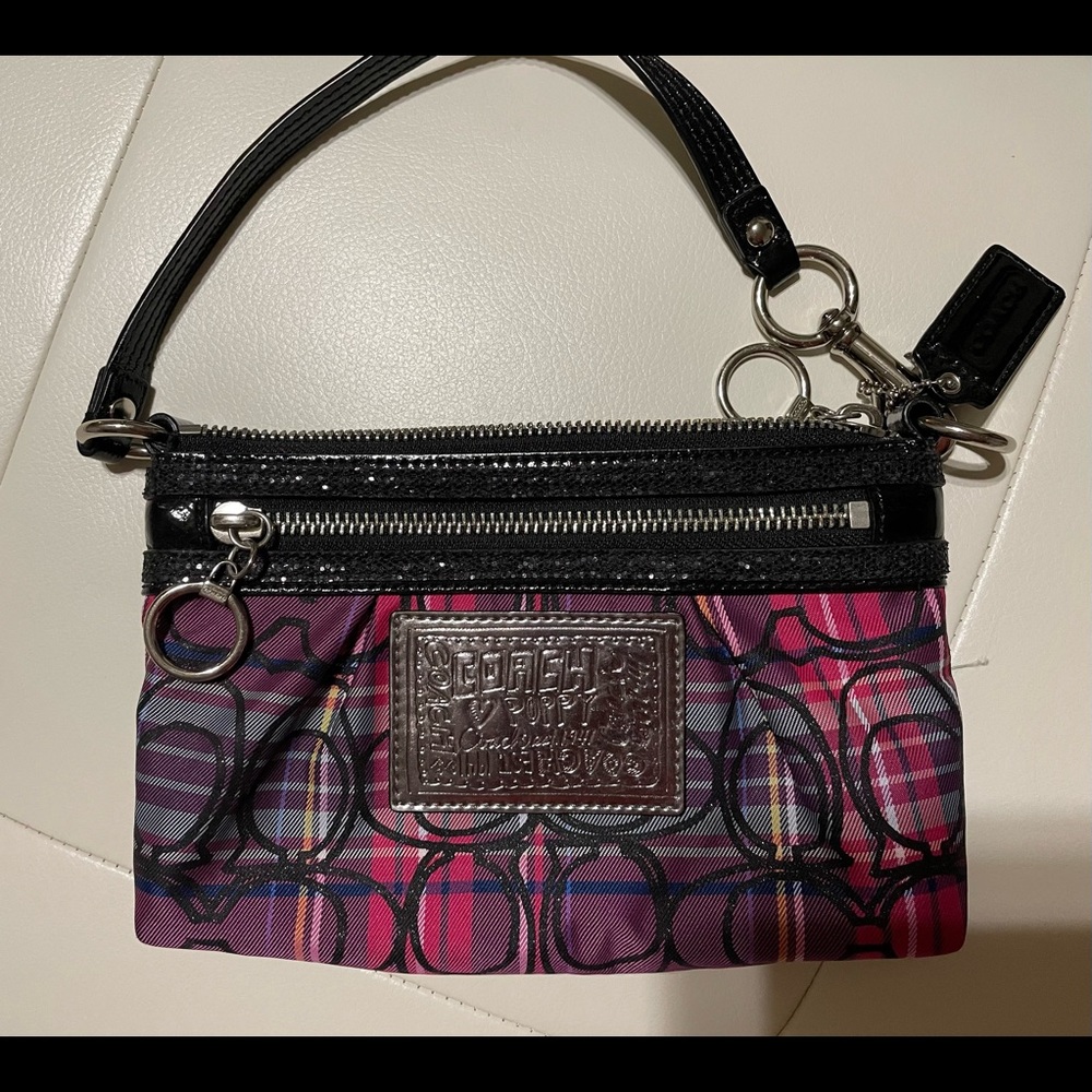 Coach wristlet with pink and purple plaid and glitter around the zipper area